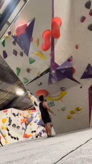 Sizing up a problem at an indoor bouldering wall.