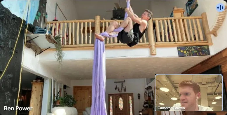 Ben on aerial silks, mid-call with Cam.